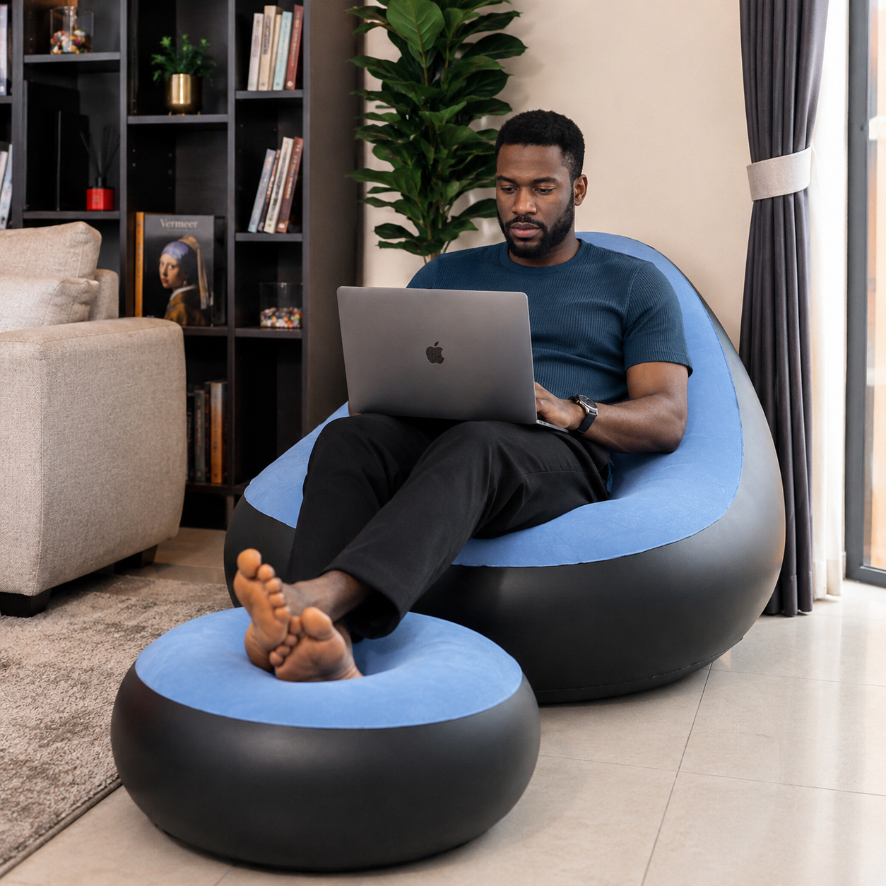 Man working on laptop in air sofa